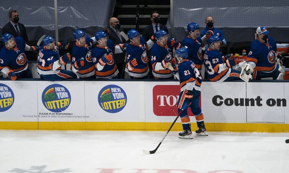 New York Islanders Center Kyle Palmieri (21) skates past the bench and is congratulated by teammates for scoring a goal during the third period of the National Hockey League game between the New Jersey Devils and the New York Islanders on May 8, 2021, at the Nassau Veterans Memorial Coliseum in Uniondale, NY.