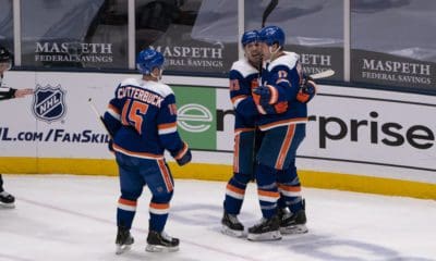 New York Islanders Center Casey Cizikas (53) and New York Islanders Right Wing Cal Clutterbuck (15) congratulate New York Islanders Left Wing Matt Martin (17) for scoring a goal during the third period of the National Hockey League game between the Buffalo Sabres and the New York Islanders on March 4, 2021, at the Nassau Veterans Memorial Coliseum in Uniondale.