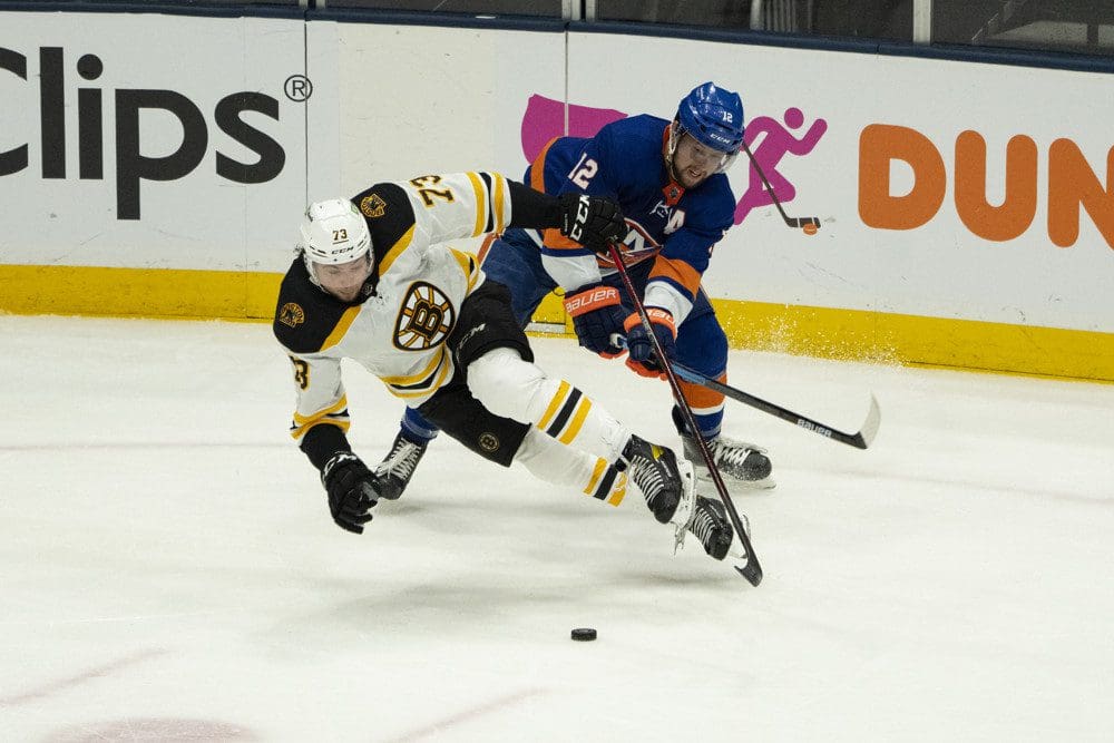 UNIONDALE, NY - JUNE 03: New York Islanders Right Wing Josh Bailey (12) and Boston Bruins Defenceman Charlie McAvoy (73) battle for the puck during the third period of Game 3 of the NHL Stanley Cup Playoffs Second Round between the Boston Bruins and the New York Islanders on June 3, 2021, at the Nassau Veterans Memorial Coliseum in Uniondale, NY. (Photo by Gregory Fisher/Icon Sportswire)